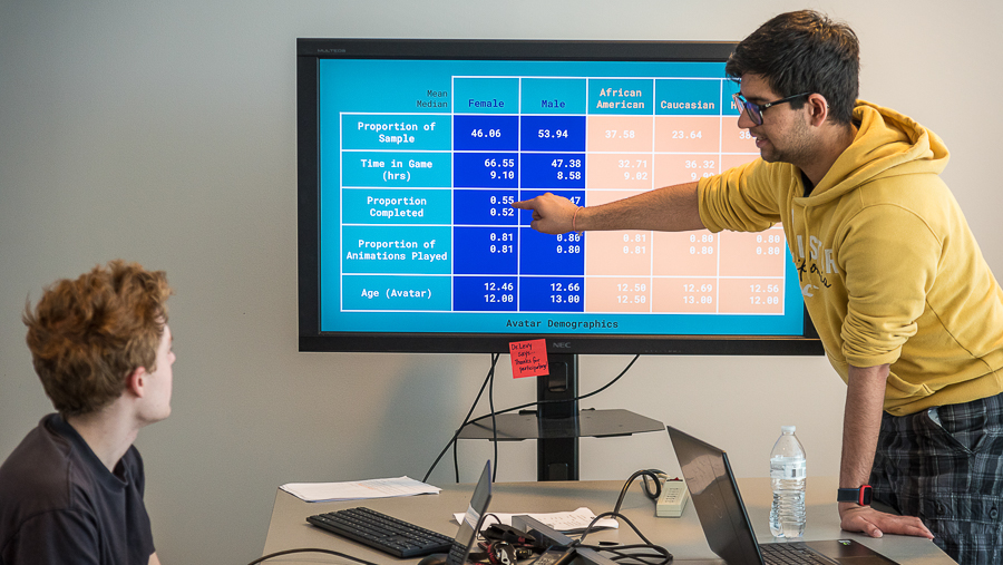 one student showing another student a data table on a monitor