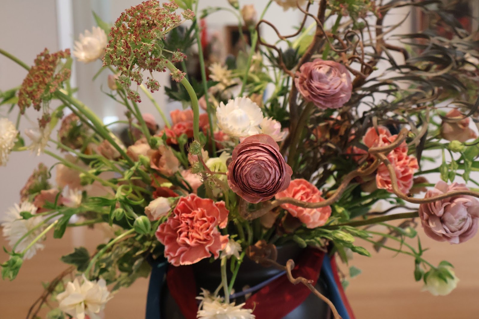 Floral materials: Branches, ranunculus, carnations, Queen Anne's lace, white straw flowers, eryngium 'aquarius questar, lisianthus