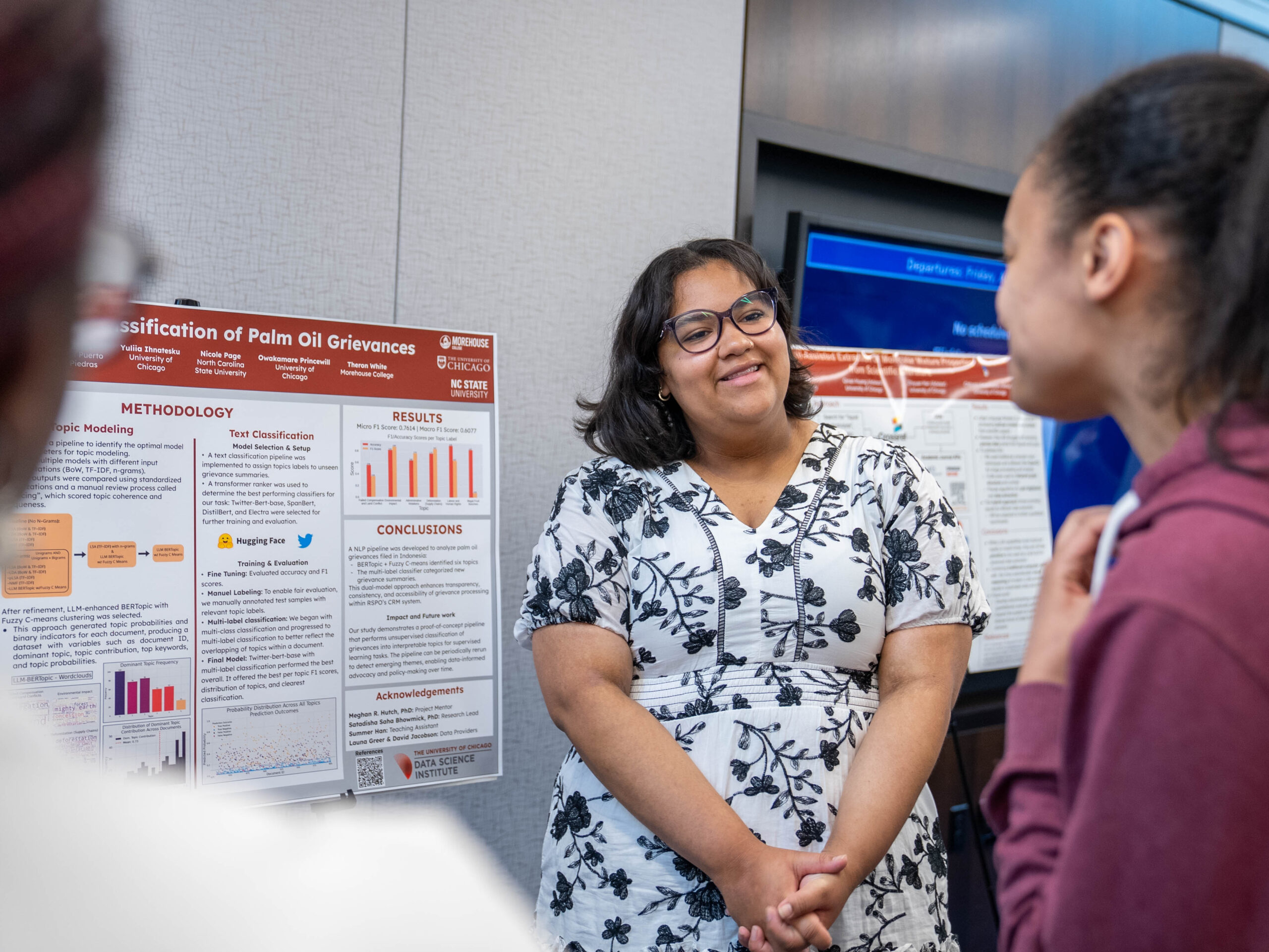 Nicole Page discusses her summer project with Symposium attendees while presenting her accompanying researh poster.